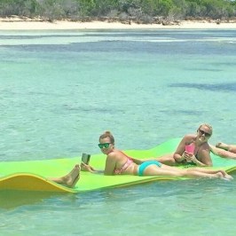 a group of people riding on the back of a boat in the water