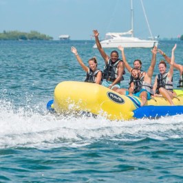 a group of people riding on the back of a boat in the water