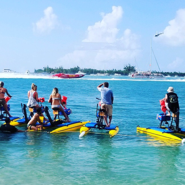 a group of people riding on the back of a boat in the water