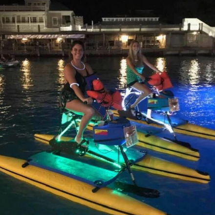 a group of people riding on the back of a boat in the water